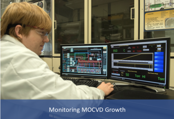 Researcher at computer monitoring growth reactor