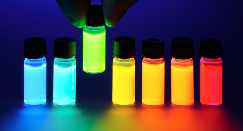 Tubes of colored liquid are shown and are fluorescent