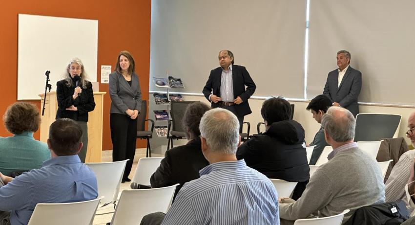 presenters speak to a roomful of people