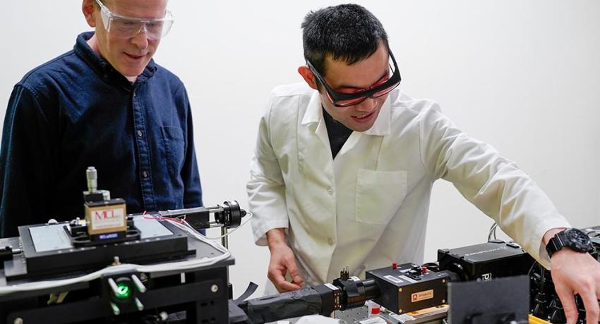 Two men in a lab adjusting a single-molecule microscope
