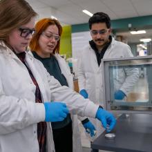 Man and two women in a lab readying a sample of cellulose